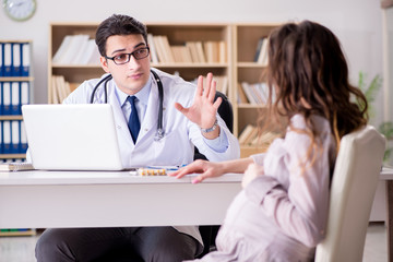 Fototapeta premium Pregnant woman visiting doctor for consultation