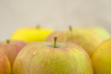 Fresh, juicy apples with drops of water on the table