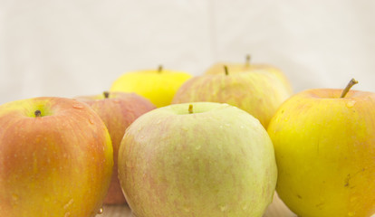 Fresh, juicy apples with drops of water on the table