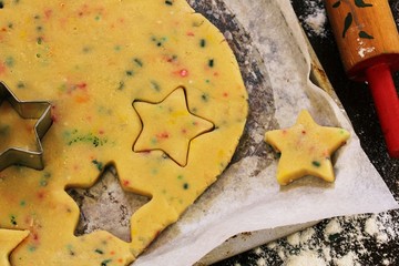 Xmas Baking concept / Cutting homemade sugar sprinkle cookie dough with star cutter