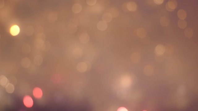 Celebration theme background displaying blurred fireworks shooting, exploding, glowing, falling like confetti in red and golden colors colours