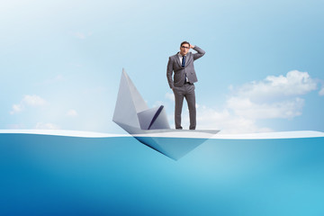 Businessman escaping sunken paper boat ship