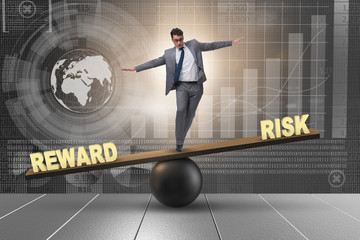 Businessman balancing between reward and risk business concept