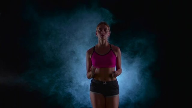 Running sport girl. Front view. Black screen in the smoke. Slow motion