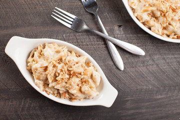 
Freshly made pasta with creamy sauce and breadcrumbs on top with forks by side
