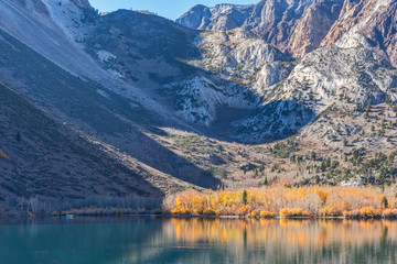 Obraz premium Aspens reflected in Convict Lake at the end of the fall season in the Eastern Sierras.