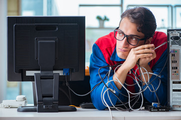 Computer repairman working on repairing computer in IT workshop