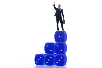 Businessman balancing on top of dice stack in uncertainty concep