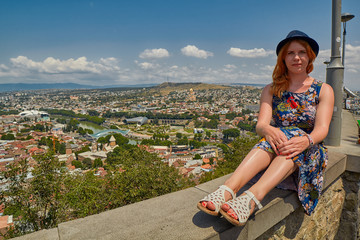 Fototapeta na wymiar Young Woman Tourist Against Tbilisi Cityscape