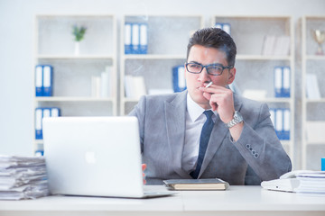 Businessman smoking in office at work