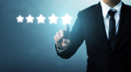 Businessman pointing five star symbol to increase rating of company