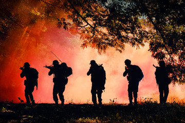 Thai soldier holding gun in full army uniform. Rangers to find news, kneeling and looking at the enemy, the battle in the mountain forests.Tactical military training ground