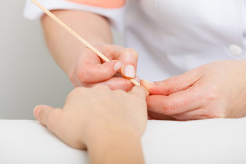 Obraz na płótnie Canvas Preparing nails before manicure, pushing back cuticles