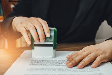 Close-up hand stamping of businesswoman for signing approval on documents , business concept