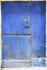 Old door of blue wood divided into three parts and with lock in one of them formerly very typical of the towns of Galicia