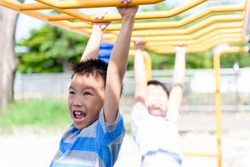 Obraz premium Young asian boy hang out door playground