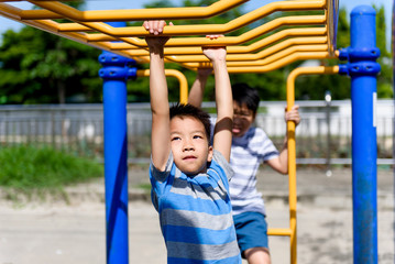 Obraz premium Young asian boy hang out door playground