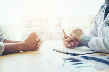 Doctors and patients sit and talk to the patient about medication. At the table near the window in the hospital.
