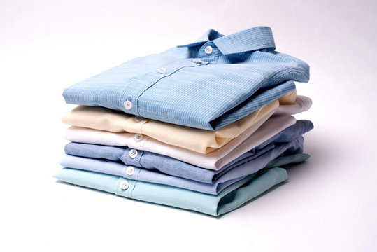 Classic men's shirts stacked on white background.