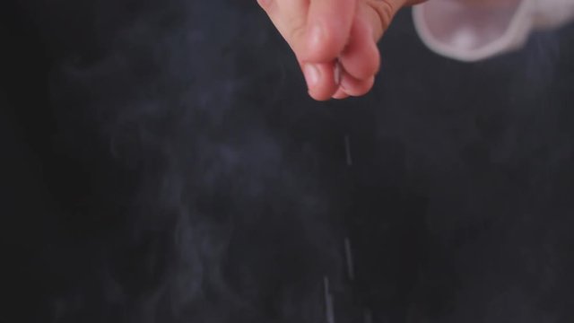 Close up of chef's hand salting food