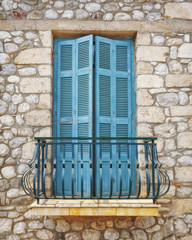 Greece, wooden green balcony window of traditional stone house