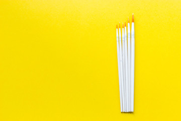 Set of Paint brushes on yellow background and copyspace