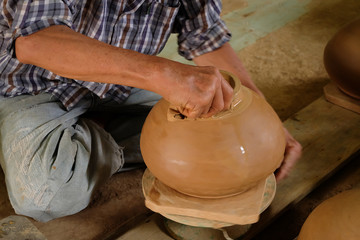 Obraz na płótnie Canvas Close up hands working on pottery wheel