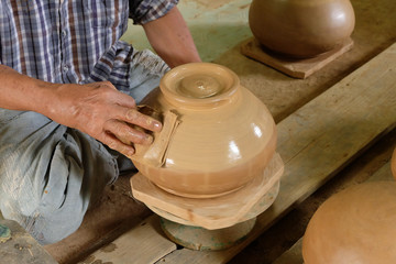 Close up hands working on pottery wheel
