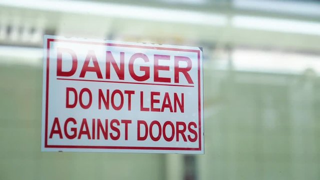 Doors close and reveal warning sign Do Not Lean Against Doors 