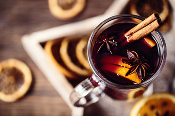 Christmas hot mulled wine in a glass with spices and citrus fruit. Mulled wine with cinnamon, anise...