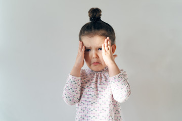 little young girl with her hair gathered on top posing for a portrait in natural light with a...