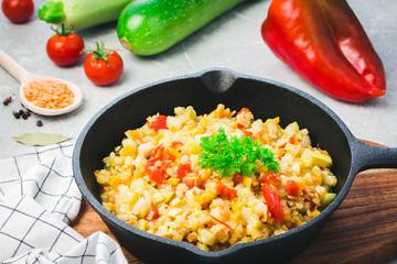 Healthy zucchini tomato lentil saute in cast iron skillet and ingredients. Vegan side dish....