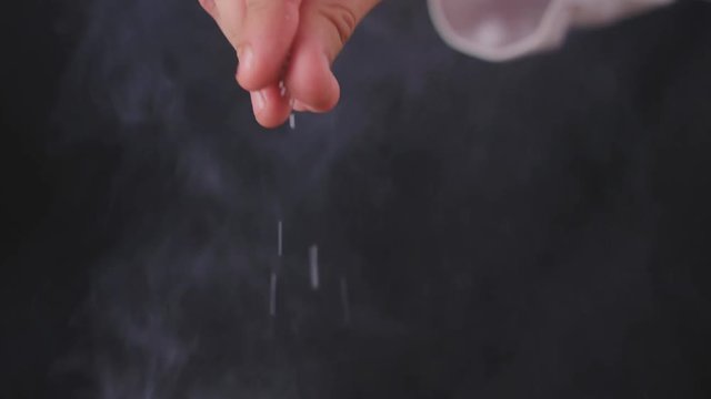 Close up of chef's hand salting food