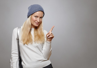 Young woman pointing finger at copy space.