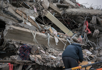 Man searching for goods in Modern destroyed building ruins closeup