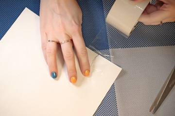 Female hand does paper transparent tape