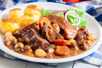 Beef Bourguignon stew served with baked potatoes