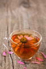 Cup of echinacea tea on old wooden table with copy space for your text