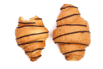 bitten croissant decorated with chocolate sauce isolated on white background, top view