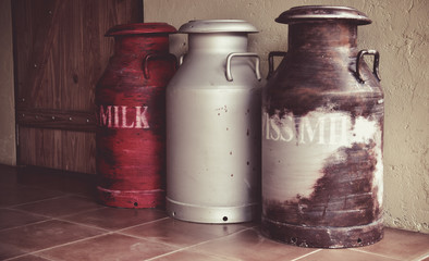 Vintage milk cans on wooden background