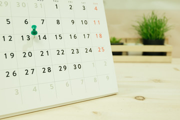calendar placed on wooden table has ornamental plants in wood basket are background. image for business, object, decorated, equipment, education concept