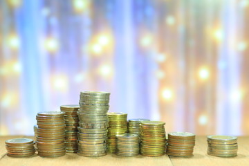 Coin stack with blur light dreamy bokeh background. Business, finance and saving concept.