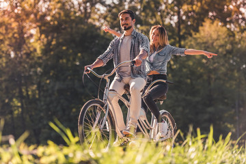 Couple with a tandem bicycle - obrazy, fototapety, plakaty