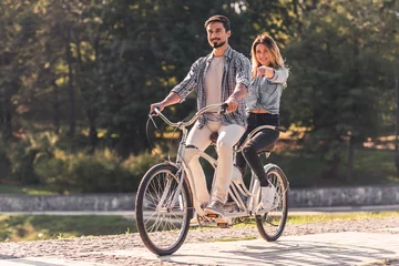 Tuinposter Couple with a tandem bicycle © georgerudy