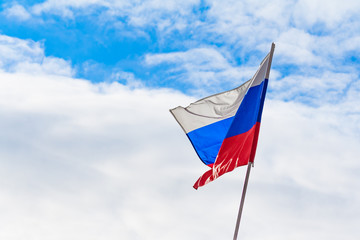 Flag of the Russian Federation fluttering in the wind a background of blue sky and clouds
