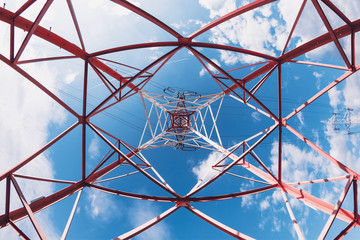 Low Angle View Of High Voltage Electricity Tower With Cables Against Cloudy Blue Sky