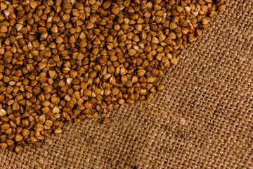 Pile of the raw buckwheat on sackcloth. Top view