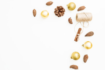 Christmas or New Year frame of golden decoration, twine and pine cones on white background. Flat lay, top view