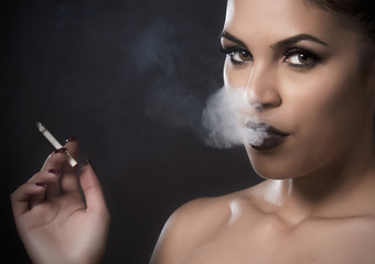 Obraz premium Beautiful woman with smoke from a cigar
