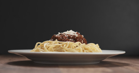 classic spaghetti bolognese with parmesan on plate on table